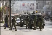  ?? MAJDI MOHAMMED — THE ASSOCIATED PRESS ?? Israeli soldiers take up positions Sunday at the scene of a Palestinia­n shooting at the Hawara checkpoint near the West Bank city of Nablus.