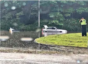  ??  ?? Wet work: Police at the scene of flooding near Edinburgh Airport