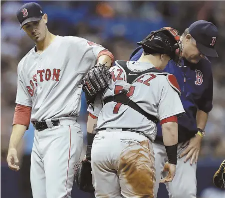  ?? AP PHOTOS ?? GOOD START: Rick Porcello pats catcher Christian Vazquez on the back after being taken out by John Farrell in the eighth inning of last night’s Red Sox win against the Rays.