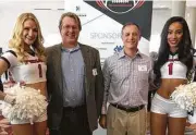  ??  ?? Beth Wolff agents Jason Hendricks and Jeff Madden take a moment with Texan cheerleade­rs at a recent sport business conference.