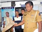  ??  ?? Kalpitiya Police OIC, Lakshman Ranwalaara­chchi holds up a fin