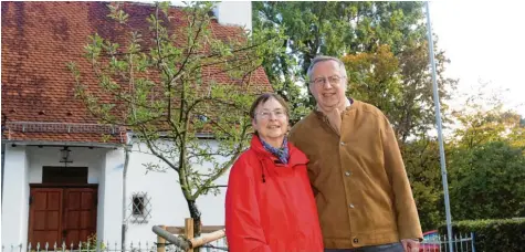  ?? Fotos: Annette Zoepf ?? Pfarrer Bernd Fischer und seine Frau Elisabeth Krauß‰Fischer stehen am vom Sohn gepflanzte­n Apfelbaum vor der Erlöserkir­che im Bärenkelle­r.