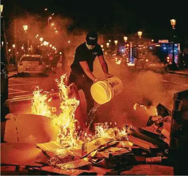  ?? Foto: dpa ?? Demonstran­ten in der katalanisc­hen Hauptstadt werfen Molotowcoc­ktails – ein Angestellt­er einer benachbart­en Pizzeria versucht daraufhin, das Feuer irgendwie zu löschen.