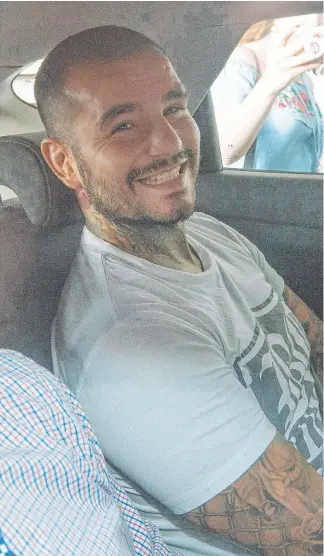  ?? Picture: JERAD WILLIAMS ?? Bikie and MMA fighter Gokhan Turkyilmaz, who was shot eight times, is brought into the Southport Watchhouse after being arrested over another shooting.