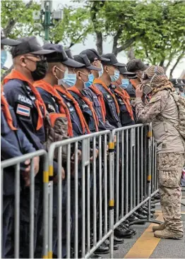  ?? Picture: GETTY IMAGES/ LAUREN DECICCA ?? STANDING FIRM: An anti-government protester approaches Thai police officers standing guard in front of The Grand Palace in Bangkok, Thailand on Sunday.