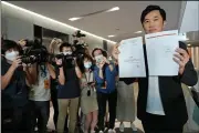  ?? (AP/Vincent Yu) ?? Lawmaker Cheng Chung-tai displays a document Thursday after he was ousted from the Legislatur­e in Hong Kong.