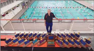  ?? ADOLPH PIERRE-LOUIS/JOURNAL ?? Albuquerqu­e Academy swim coach Dave Barney poses with some of the 35 state championsh­ip trophies his teams have won in his time running the program.