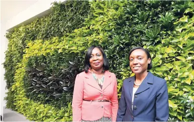  ??  ?? Delories Jones (left) and Terrian Fletcher of JN Fund Managers enjoy the ‘green wall’.