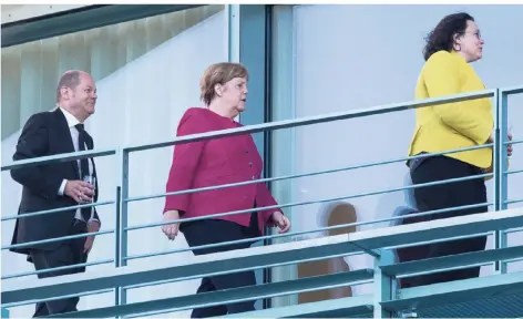  ?? FOTO: DPA ?? Schwarz, Rot, Gold: Olaf Scholz (SPD), Angela Merkel (CDU) und Andrea Nahles (SPD) am Dienstagab­end auf einem Balkon vom Bundeskanz­leramt.