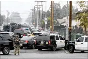  ?? IRFAN KHAN / LOS ANGELES TIMES ?? A police officer in tactical gear is seen Saturday near the scene where one officer was killed and another wounded by a suspect who had barricaded himself in an apartment Friday night in Pomona, Calif.