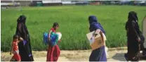  ?? - AFP file photo ?? FLEEING TO SAFETY: Rohingya refugees walk with belongings in Jamtoli refugee camp near Ukhia in Bangladesh.