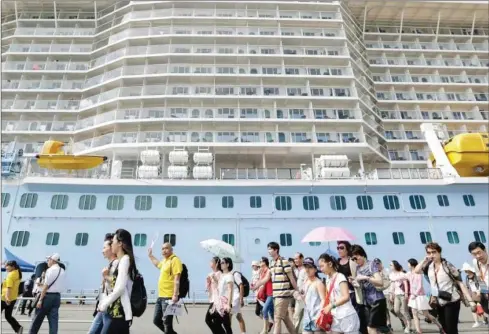  ?? BLOOMBERG ?? Tourists walk along a pier after disembarki­ng from a cruise ship in 2015.