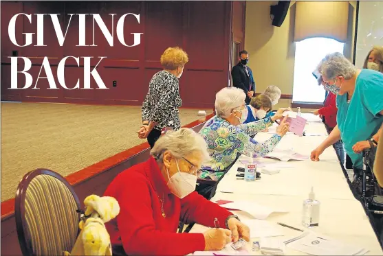  ?? SHEA SINGLEY — READING EAGLE ?? The Highlands of Wyomissing residents, seated from front to back, Eve Kimball, Jane Bitner, Carol Duchynski and Diana Kleiner volunteer at the two-day COVID-19 vaccine clinic on Monday. Sponsored by The Highlands and Esterbrook Pharmacy in West Reading, the goal of the clinic is to vaccinate up to 1,300 community members.