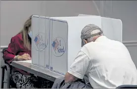  ?? TASOS KATOPODIS / GETTY IMAGES ?? Voters cast ballots, spaced apart due to COVID-19 at the Fairfax Government Center on Friday in Fairfax, Va.