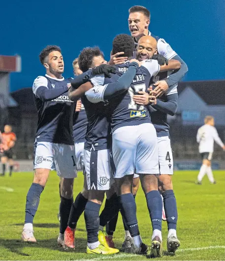  ??  ?? CLINICAL: Max Anderson fires Dundee ahead, left, while Jonathan Afolabi is mobbed by team-mates after making it 2-0 at Somerset Park, above.