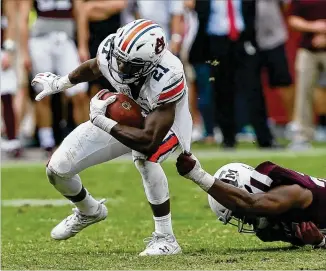  ?? BOB LEVEY / GETTY IMAGES ?? Auburn running back Kerryon Johnson drags Texas A&M’s Tyrel Dodson during his 145-yard performanc­e in the Tigers’ 42-27 victory last weekend. Johnson is averaging 124 yards per game.