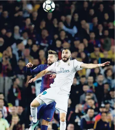  ?? AP ?? Real Madrid’s Karim Benzema (right) and Barcelona’s Gerard Piqué jump for the ball during their Spanish LaLiga match, dubbed ‘El Clasico’, at Camp Nou in Barcelona, Spain, yesterday.