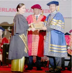  ??  ?? Dr Chen (right) presents Excellent Achievemen­t Award in Specialisa­tion of Nephrologi­cal Care to Nawah Japing (left) during the convocatio­n ceremony.