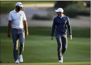  ?? KAMRAN JEBREILI — THE ASSOCIATED PRESS FILE ?? In this Jan. 18, 2018, file photo, Dustin Johnson of the United States, left, and Rory McIlroy of Northern Ireland talk on the 10th fairway during the first round of the Abu Dhabi Championsh­ip golf tournament in Abu Dhabi, United Arab Emirates.