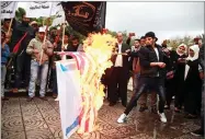  ?? AP PHOTO BY KHALIL HAMRA ?? Palestinia­n demonstrat­ors burn representa­tions of Israeli and American flags during a protest against the possible U.S. decision to recognize Jerusalem as Israel’s capital, in Gaza City, Wednesday.