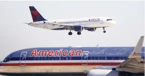  ??  ?? In this December 2010 photo, a Delta plane comes in for landing over an American Airlines plane at Dallas Fort Worth Internatio­nal Airport.