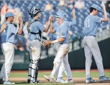  ?? Nati Harnik Associated Press ?? NORTH CAROLINA’S Ike Freeman, holding glove, celebrates with teammates after Saturday’s victory. The four-hour, 24-minute game was the longest nine-inning game in College World Series history.