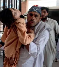  ?? AP ?? A man rushes a girl to a hospital in Peshawar on Monday. —