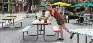  ?? CHAD RHYM / NEW YORK TIMES ?? Emily Magnuson paints a table as part of a project through a nonprofit, The Downtown District, in Iowa City, Iowa. Service-provider employment increased 389,000 in August.