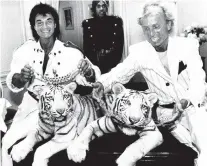  ?? AP PHOTO/SCOTT MCKIERNAN ?? Las Vegas magicians Roy Horn, left, and Siegfried Fischbache­r pose in New York in 1987 with their rare white tigers.