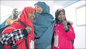  ?? AP PHOTO ?? Halima Mohamed embraces her daughters Muzamil Shalle, 14, ( left) and Miski Shalle, 11, ( right) after their arrival from Somalia Wednesday at John F. Kennedy Internatio­nal Airport in New York. The family had been apart for seven years but the reunion...