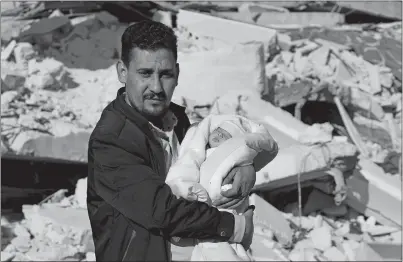  ?? GHAITH ALSAYED AP PHOTO ?? Khalil al-Sawadi holds Afraa, a baby girl who was born under the rubble caused by an earthquake that hit Syria and Turkey earlier this month. They were in the Syrian town of Jinderis in Aleppo province. Afraa left the hospital Monday and has gone to her new home with her paternal aunt’s family. This occurred as a new earthquake hit Turkey and Syria on Monday.