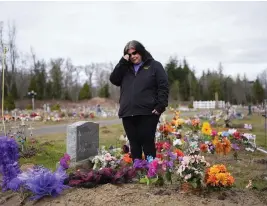  ?? LINDSEY WASSON / AP ?? Evelyn Jefferson, a crisis outreach supervisor for Lummi Nation, stands at the grave of her son Patrick George Jr., who died last September due to an overdose of street drugs containing the synthetic opioid carfentani­l. Jefferson had to wait a week to bury her son due to several other overdose deaths in the community.