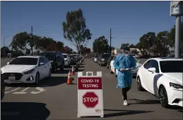  ?? JAE C. HONG — THE ASSOCIATED PRESS FILE ?? Student nurse Ryan Eachus collects forms as cars line up for COVID-19 testing at a testing site set at the Orange County Fairground­s in Costa Mesa on Nov. 16.