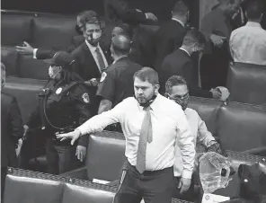  ?? J. SCOTT APPLEWHITE/ AP ?? Rep. Ruben Gallego, D- Ariz., and other lawmakers evacuate the House chamber after protesters broke into the Capitol on Wednesday. Police told lawmakers to grab gas masks and rushed them to a secure location.