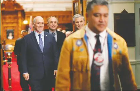  ?? CHAD HIPOLITO/THE CANADIAN PRESS ?? Chief Terry Teegee leaves the legislativ­e assembly with Premier John Horgan, Green Party Leader Andrew Weaver and Liberal Leader Andrew Wilkinson in tow after historic legislatio­n designed to end discrimina­tion against B.C.’s Indigenous peoples was introduced.