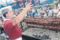  ?? VINCE TALOTTA /TORONTO STAR FILE PHOTO ?? George Avgeropoul­ous of Athens restaurant watches goat meat cook slowly over an open barbeque while calling for customers.
