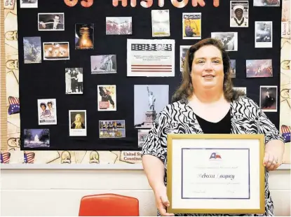  ?? Diana L. Porter / For the Chronicle ?? Katy High School U.S. History teacher Rebecca Lacquey stands in her classroom with the Outstandin­g Teaching of the Humanities award she received this month from Humanities Texas.