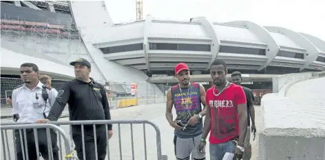  ?? RYAN REMIORZ/THE CANADIAN PRESS ?? Asylum seekers from Haiti leave Olympic Stadium on Thursday in Montreal. The stadium is being used as temporary housing to deal with the influx of asylum seekers arriving from the U.S.