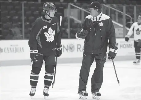  ?? JACK BOLAND / POSTMEDIA NETWORK ?? Toronto Maple Leafs rookie Mitch Marner chats with head coach Mike Babcock during a recent practice. Marner, part of the outstandin­g rookie corps that has the team’s rebuild ahead of schedule, ought not to be considered trade material, writes the...