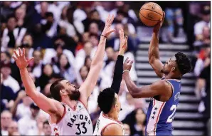  ?? AP/The Canadian Press/FRANK GUNN Philadelph­ia guard Jimmy Butler (right) shoots over Toronto center Marc Gasol (left) and guard Danny Green on Monday night in Toronto. ??