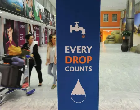  ?? PICTURE: HENK KRUGER/AFRICAN NEWS AGENCY (ANA) ?? SEEPING THROUGH: People arriving at Cape Town Internatio­nal Airport are greeted by water saving messages.