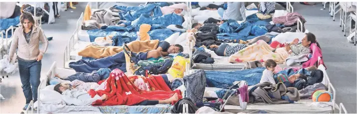  ?? FOTO: DPA ?? Flüchtling­e schlafen auf Feldbetten in einem Notaufnahm­elager in Hanau.