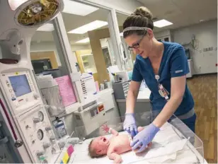  ??  ?? Nurse Jessica Dean tends to a newborn at Neosho Memorial.