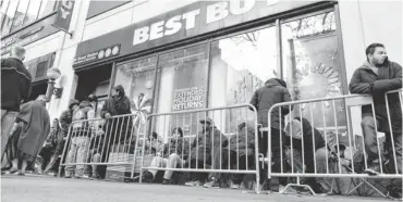  ?? STAN HONDA, AFP/ GETTY IMAGES ?? People wait in line to purchase the Sony PlayStatio­n 4 console outside a Best Buy store in Manhattan on Thursday.