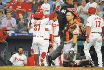  ?? Hunter Martin / Getty Images ?? The Phillies’ Odubel Herrera is congratula­ted by teammates after hitting a three-run homer off the Giants’ Jeff Samardzija in the first inning. Samardzija gave up another homer in the fourth.