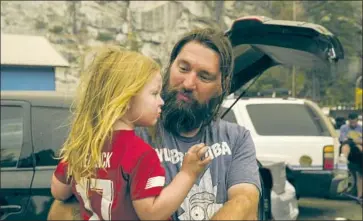  ?? Kent Nishimura Los Angeles Times ?? THE CREEK FIRE has exploded, consuming nearly 100,000 acres over the weekend and threatenin­g towns in the Sierra. Above, Jeremy Hedrick and his son, Jeep, wait to be evacuated from Shaver Lake on Monday.