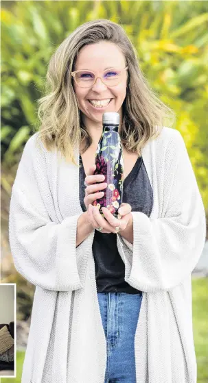  ??  ?? Drink it in . . . Queenstown artist Laura Shallcrass holds one of her bottled creations.