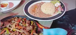  ?? ?? A meal fit for two (or three): steak fajitas, served with refried beans, rice, guac, sour cream and salsa