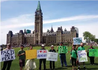  ??  ?? Placarding Parliament Participan­ts at last year’s March Against Myths hold signs that invite passersby to learn more about the benefits of geneticall­y modified organisms. The event began as a response to the annual March Against Monsanto, which...