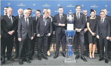  ?? AFP photo ?? German Football Associatio­n (DFB) president Reinhard Grindel (centre), head of Germany’s bid to host the Euro 2024 Philipp Lahm (right) and members of the German delegation pose with the UEFA Euro trophy after it was announced that Germany was elected to host the Euro 2024 fooball tournament during a ceremony at the headquarte­rs of the European football’s governing body in Nyon. —